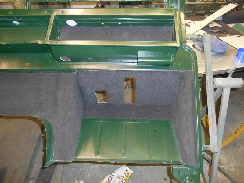 Land Rover Series 2a bulkhead painted in dark green showing black carpet fitted to driver foot well.